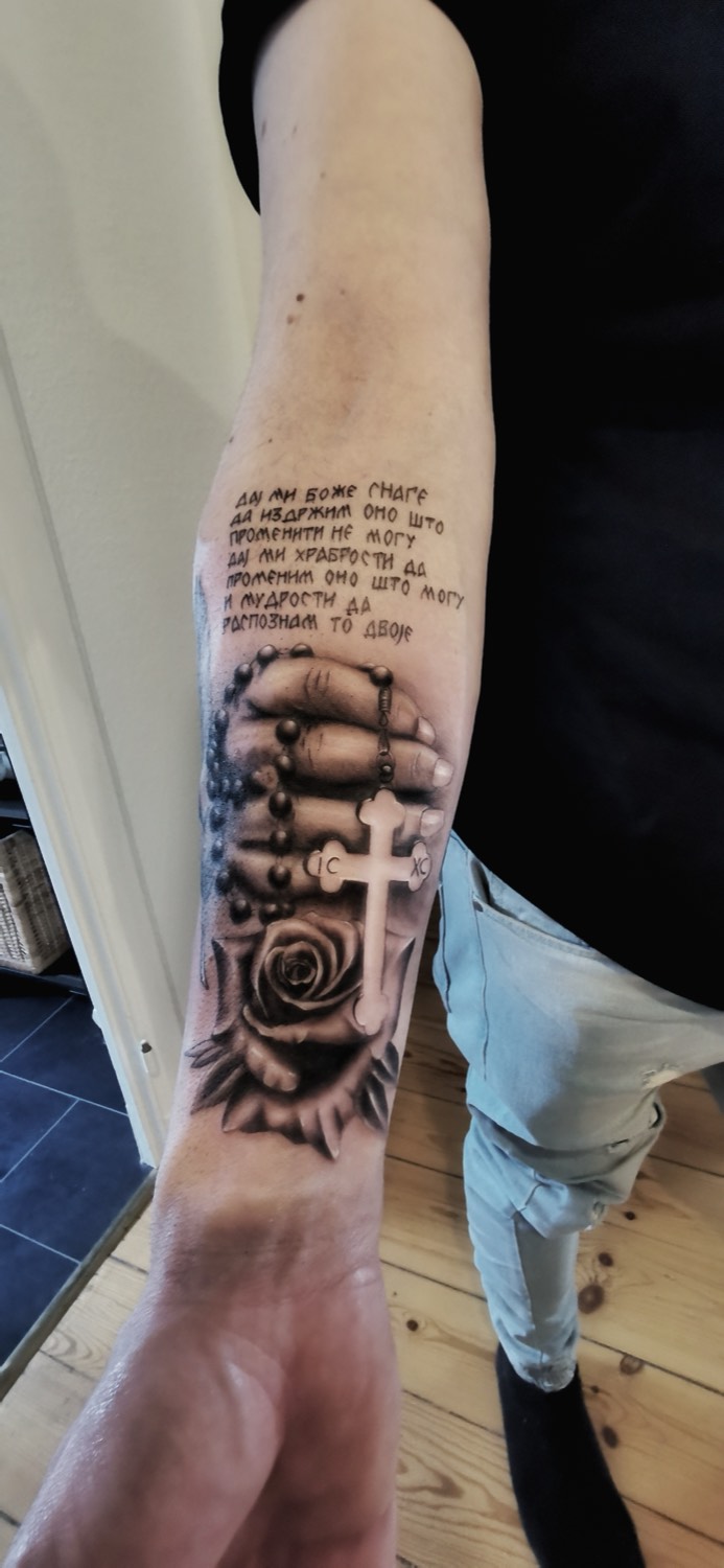 Unterarm mit Schrift, Rosenkranz, Rose und Kreuz