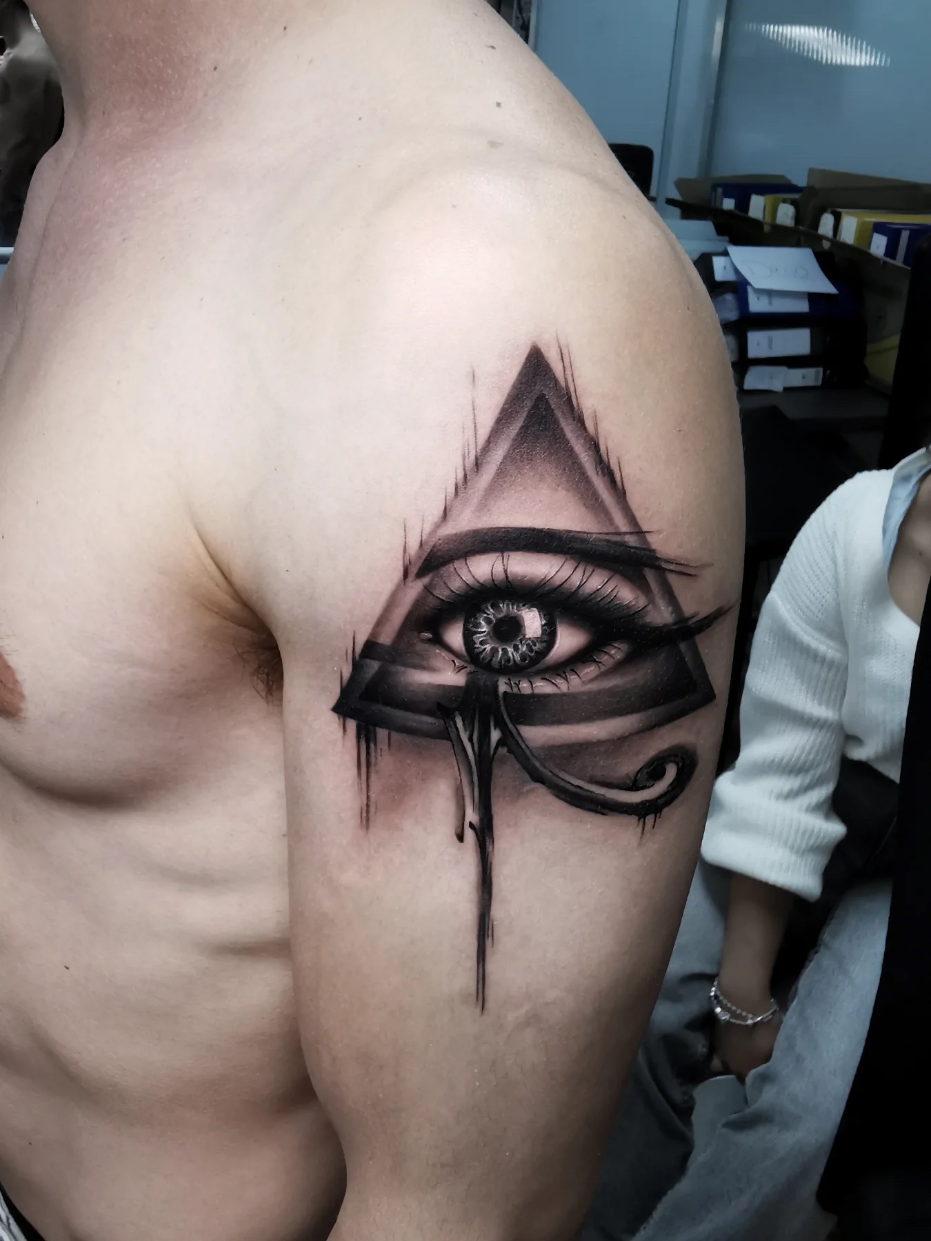 Auge in einem Dreieck auf der Schulter