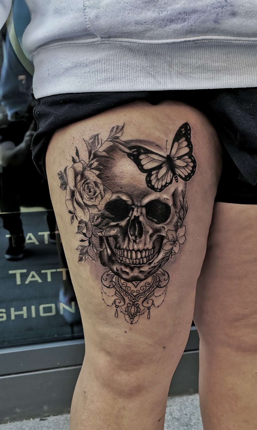Totenkopf mit Schmetterling und Rosen am Oberschenkel